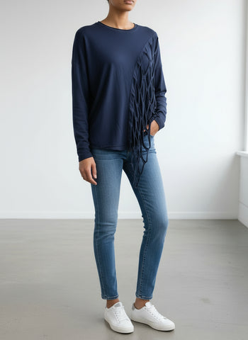 A navy plus size top with distressed slashing panels displayed on a hanger against a white background.