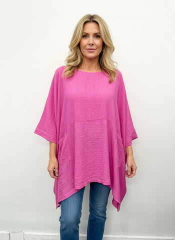A plus size casual top in fuchsia color with front pockets.