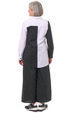 Person wearing a black and white outfit with wide-leg pants on a white background