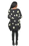 Woman wearing a black dress with green floral patterns on a white background