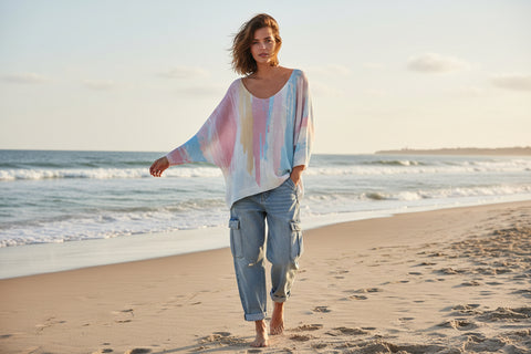 Multicolored knit sweater on a hanger against a white background