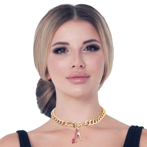 Woman wearing a gold necklace with a pink high heel charm on a white background