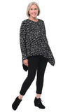 Woman wearing a black patterned top and black pants on a white background