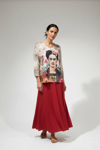 Sweater with Frida Kahlo design on a hanger against a white wall