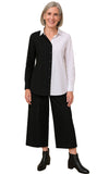Woman wearing a black and white button-up shirt with black pants on a white background