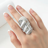 An adjustable silver ring with an irregular hammered plate design, displayed on a white surface.