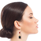 Woman wearing a lipstick-shaped earring on a white background