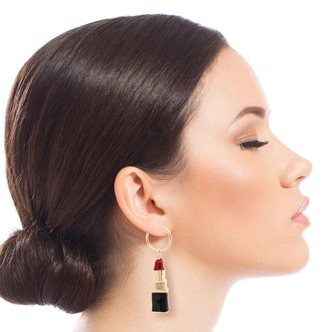 Woman wearing a lipstick-shaped earring on a white background