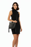 Mannequin wearing a black dress and holding a handbag on a white background