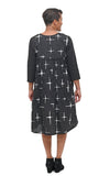 Woman wearing a black dress with white geometric patterns on a white background