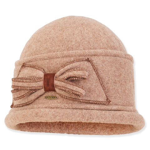 Beige turban hat with a brown bow and 'Adora' branding on a white background