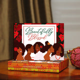 Box of 'Beautifully Blessed' holiday cards with illustrations of women on a wooden surface.