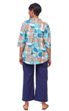 Person wearing a patterned shirt and blue pants on a white background