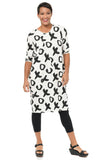 Woman wearing a black and white patterned dress on a white background