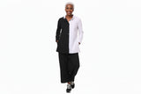 Person wearing a black and white outfit with wide-leg pants on a white background