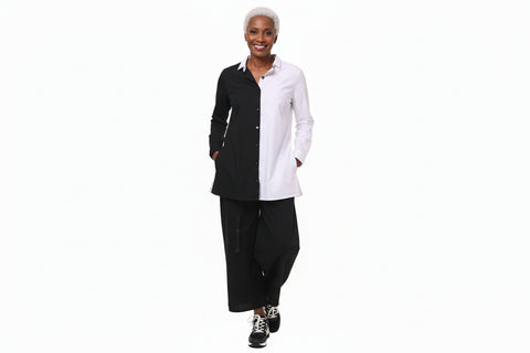 Person wearing a black and white outfit with wide-leg pants on a white background