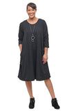 Woman wearing a black dress with long sleeves on a white background