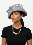 Mannequin head with a gray hat and jewelry on a white surface
