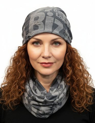 Mannequin wearing a gray scarf  and beanie set with letter pattern on a white background
