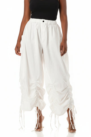 White wide-leg pants with fringe details on a white background