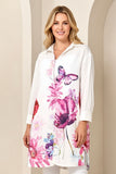 Woman wearing a white blouse with floral and butterfly designs on a beige background