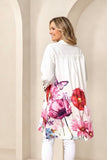 Woman wearing a white floral shirtdress against a beige archway background