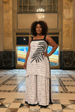 Mannequin wearing a white dress with black patterns in an indoor setting