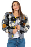 Woman wearing a floral-patterned cardigan with colorful buttons on a white background