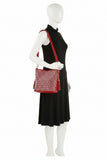 Mannequin wearing a black dress holding a red handbag on a white background