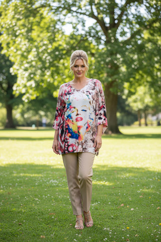 Colorful printed top on a hanger against a white background