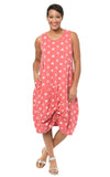 Woman wearing a pink dress with white floral pattern on a white background