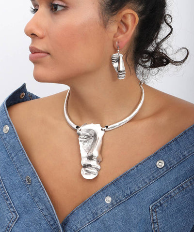 Woman wearing a silver necklace and earrings on a white background