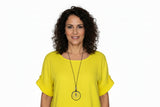 Yellow top on a hanger with a necklace