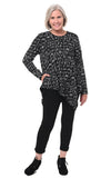 Woman wearing a black patterned top and black pants on a white background