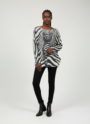 Zebra-patterned garment with a cat design on a hanger against a white background