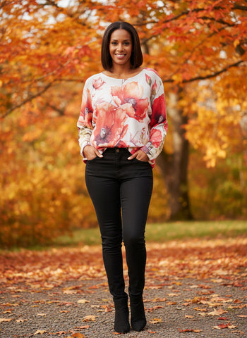 Poppy patterned mesh sweater top on a hanger against a white wall