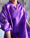 Purple shirt dress worn by a person with a neutral background