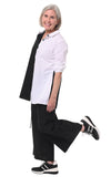 Woman wearing a black and white outfit with sneakers on a white background